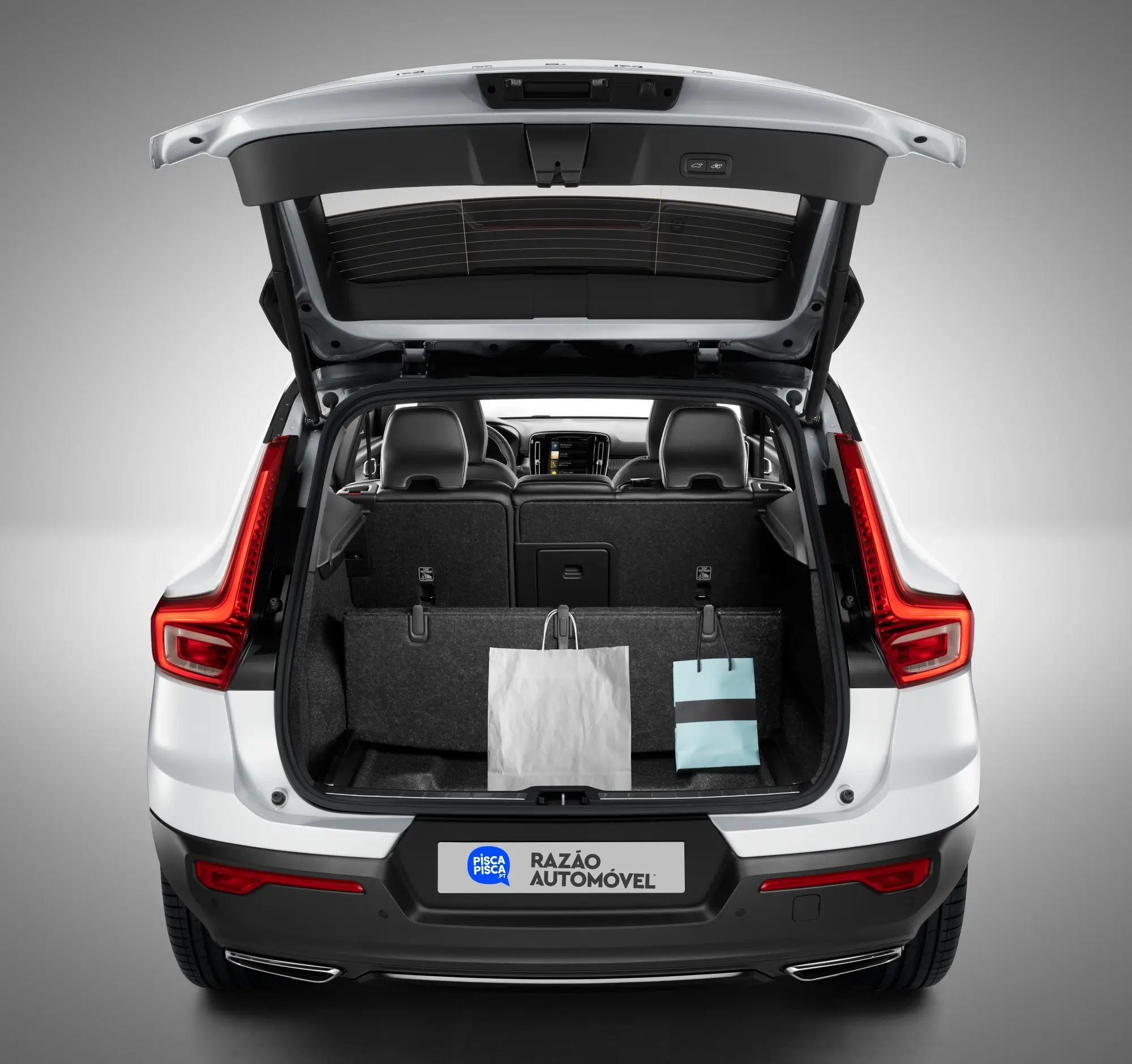 Volvo XC40 com bagageira aberta e sacos presos nos cabides