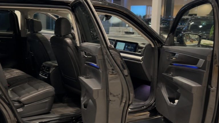 A sleek Volkswagen Teramont SUV is parked on a sunlit dealership fl…
