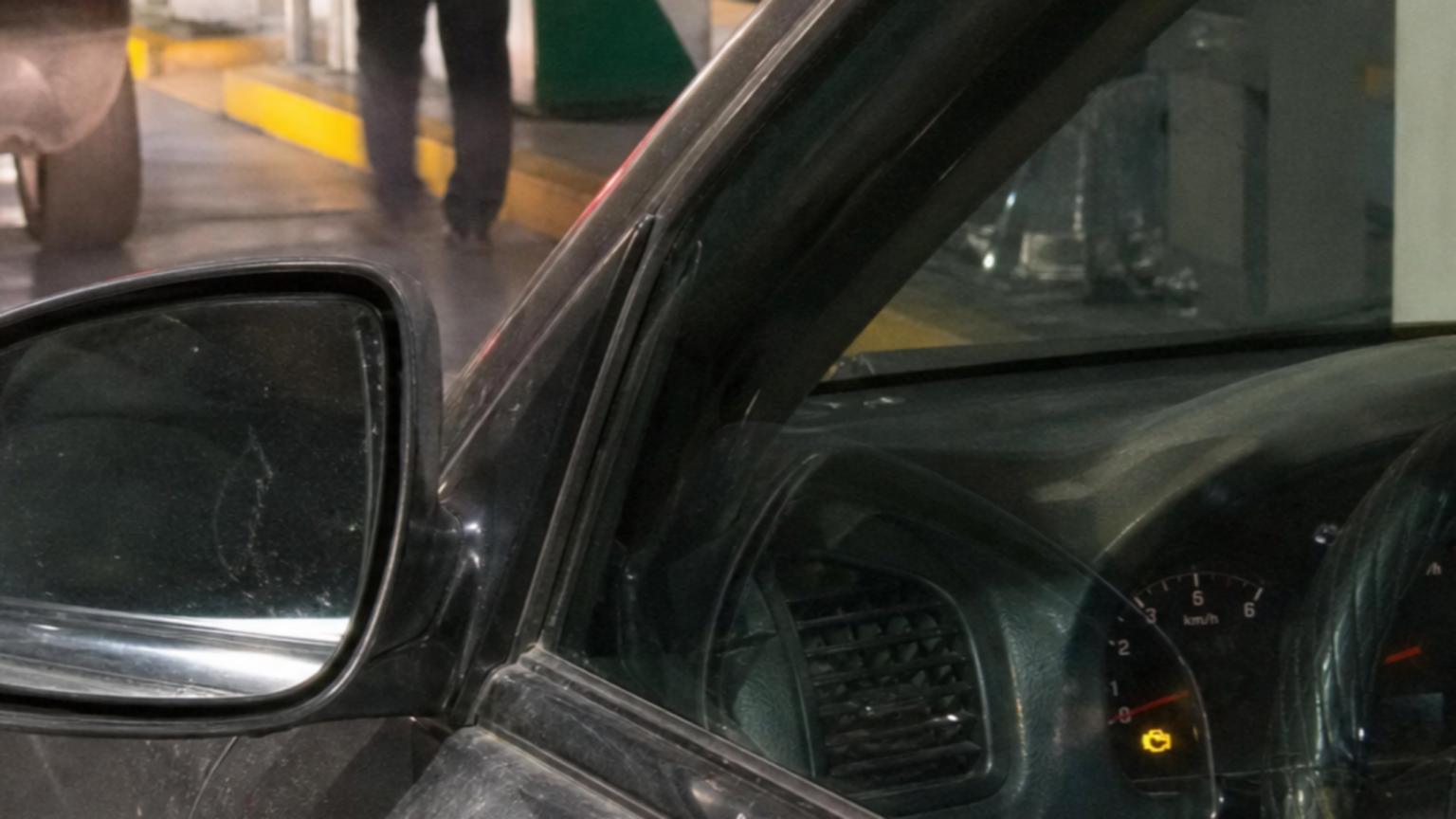 Un auto detenido frente a la entrada de un verificentro, con la luz…